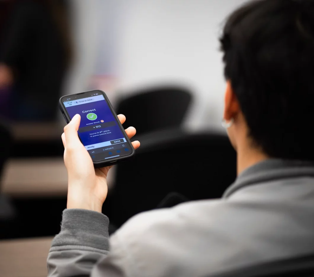 Person holding a cell phone while comparing active recall website picks, FAQs, and final study app recommendations