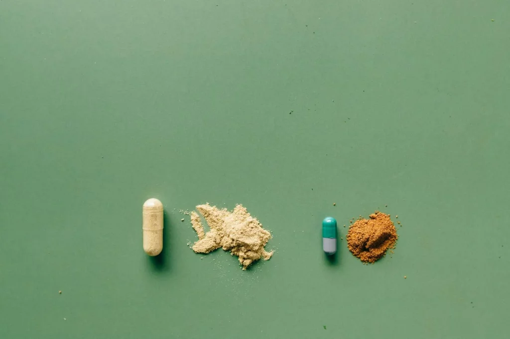 Capsules and sleep-support powders on a green backdrop illustrating the Andrew Huberman sleep cocktail concept