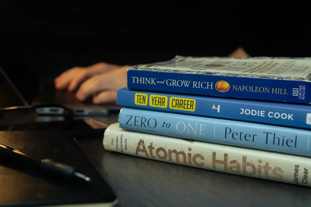 Atomic Habits Summary by Chapter for Students: 7 Proven Lessons That Actually Stick Stack of books on a wooden table beside a printable checklist for atomic habits summary by chapter