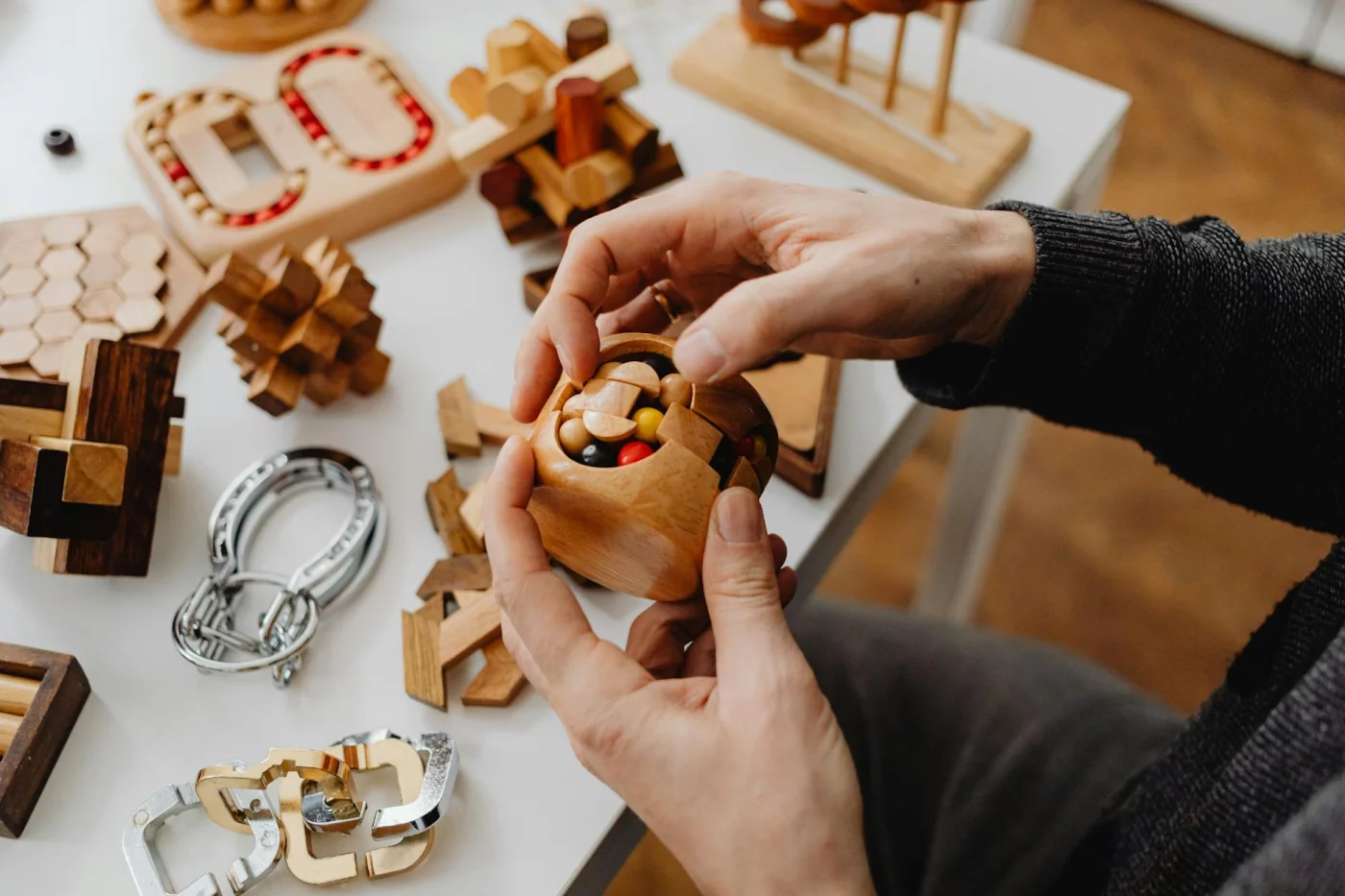 Do Brain Training Games Work for Adults? Person solving wooden puzzles as best brain games for adults are often marketed to boost memory and focus