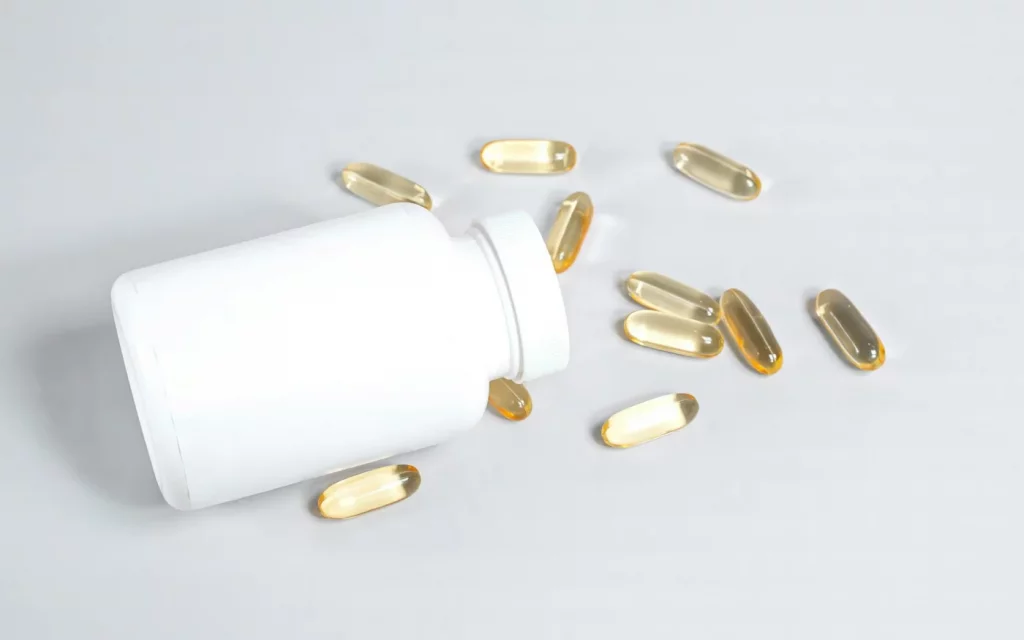 Fish oil capsules spilled from a white bottle, representing best brain supplements for adults