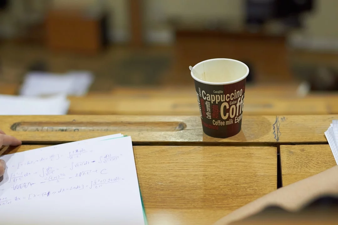 Desk coffee setup with study papers illustrating the best time to drink coffee for studying throughout the day