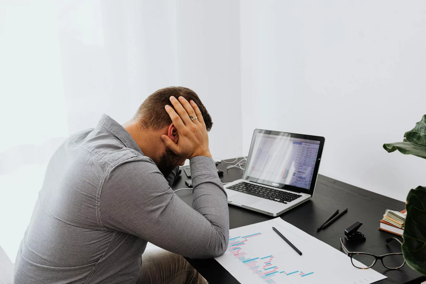 Burnout Statistics by Profession: Patterns and Risks Stressed office worker at desk reviewing burnout statistics by profession on laptop charts and graphs