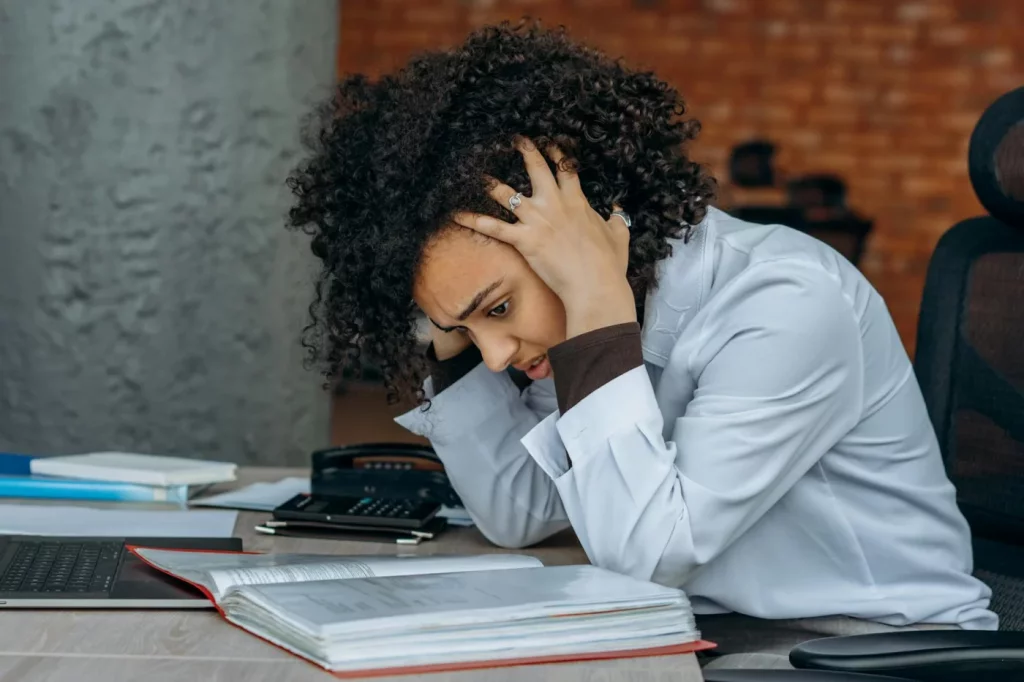Stressed woman at her office desk, illustrating how can high cortisol cause brain fog during workplace pressure