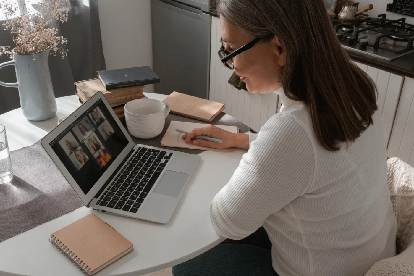 Can Your Brain Actually Multitask? 7 Evidence-Based Facts Woman on a video call taking notes, showing when can your brain actually multitask in everyday work
