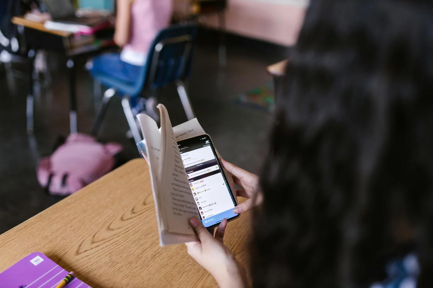 How to Do a Digital Detox for Students Without Losing Productivity Student reading a book while using a phone, illustrating digital detox for students with a 7-day checklist