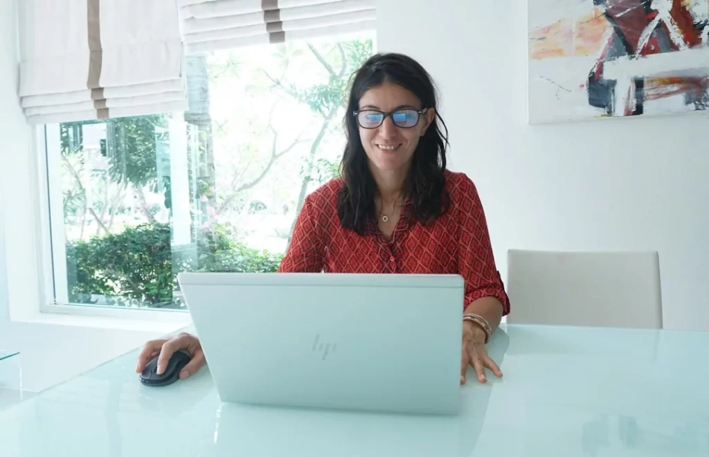 Woman working on laptop, do blue light glasses help with eye strain during long screen sessions?