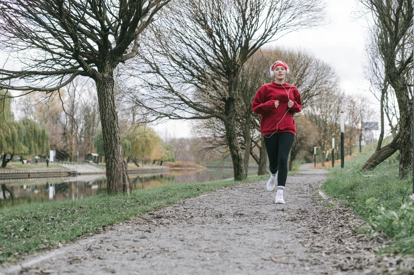 Woman jogging by a calm river in autumn, reflecting on whether does dopamine detox work for adhd