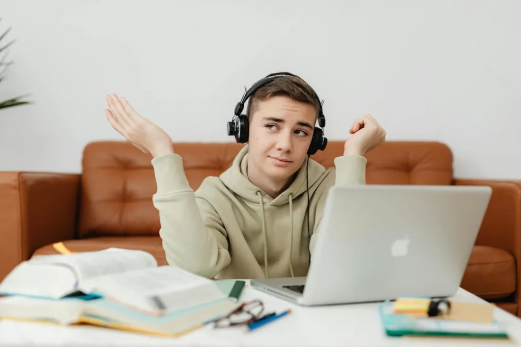 Student with laptop and headphones at home, does music help you study or distract you during online learning?
