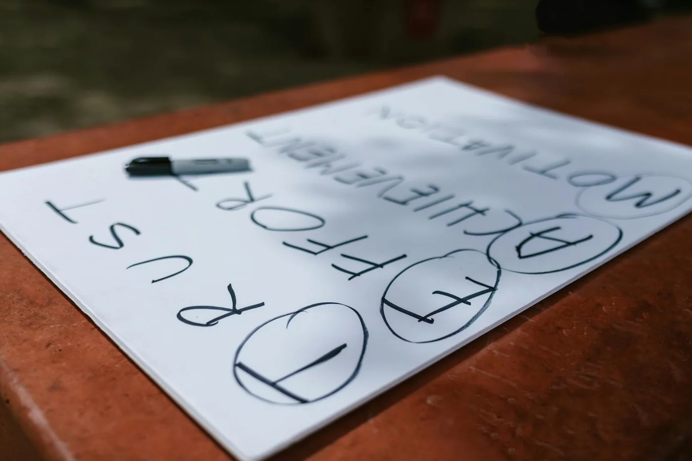 Motivational notes on a paper outdoors illustrating fear of failure and procrastination linked to imposter syndrome