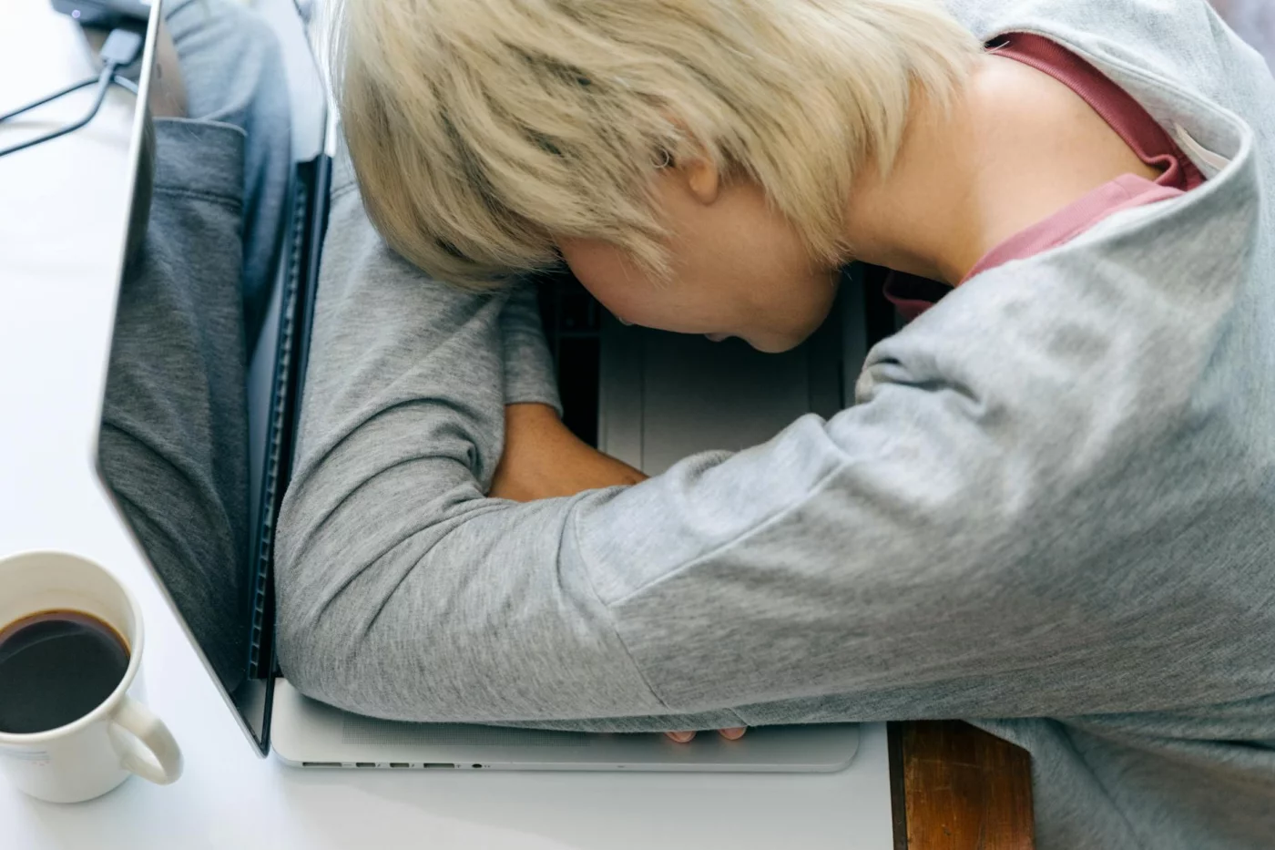 Why You Cannot Focus After Lunch: Causes and Fixes Tired woman at laptop shows why feeling sleepy after eating is called a post-lunch slump at work