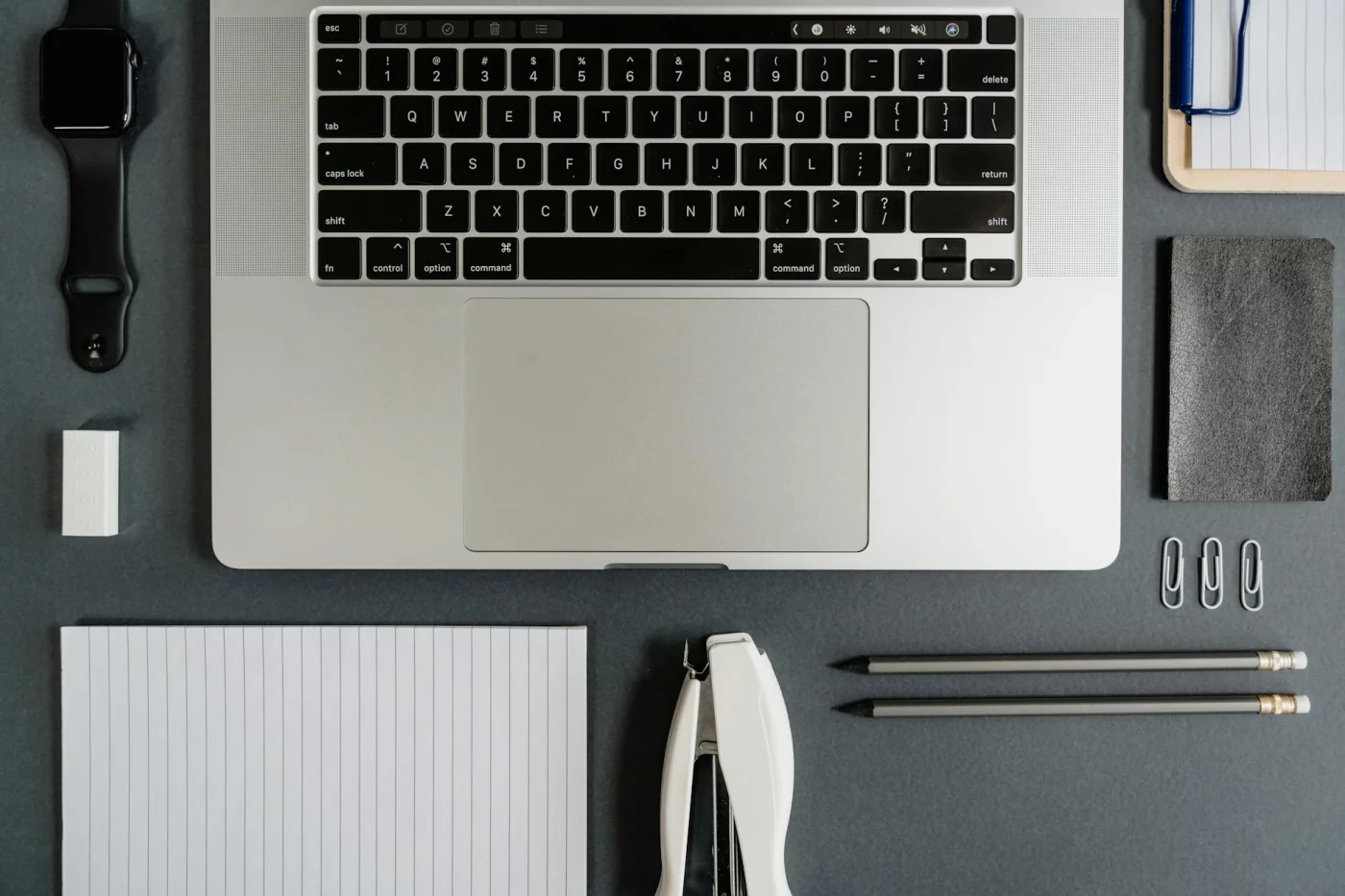 Office desk setup for getting things done gtd guide pdf: laptop, notepad, smartwatch, stationery for GTD examples