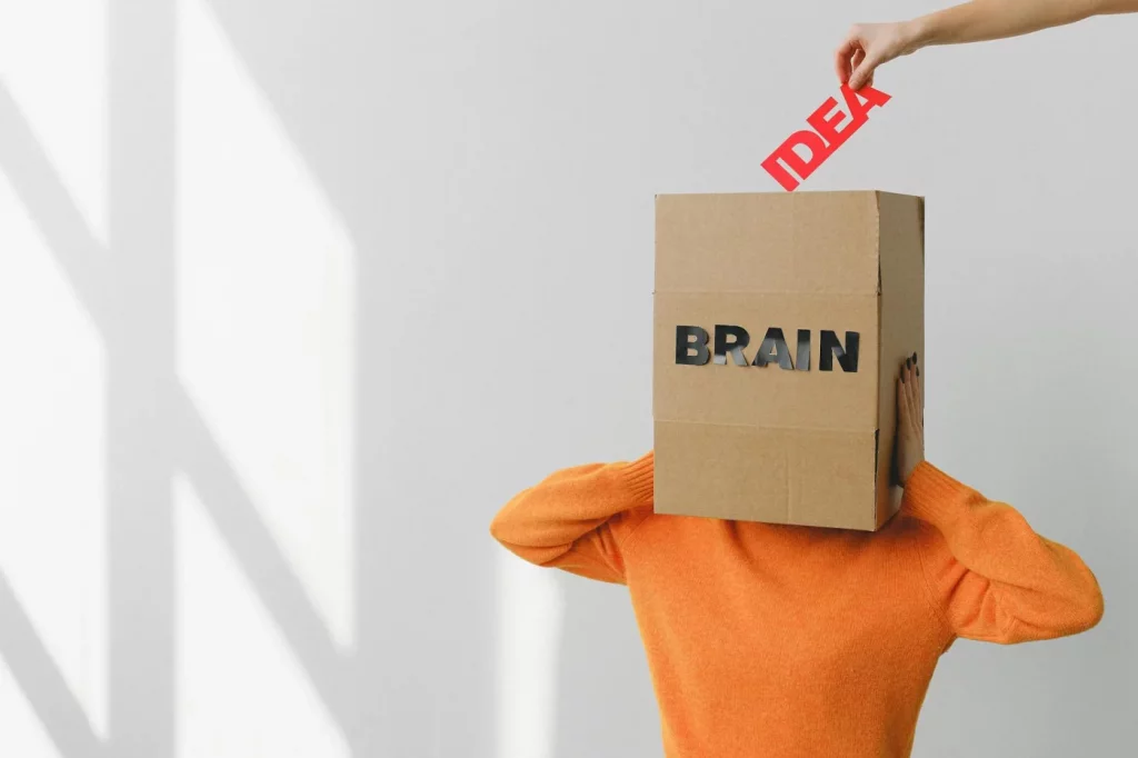 Can You Rewire Your Brain After 40? What Neuroplasticity Shows Person holding a cardboard brain, illustrating how long does it take to rewire your brain through neuroplasticity