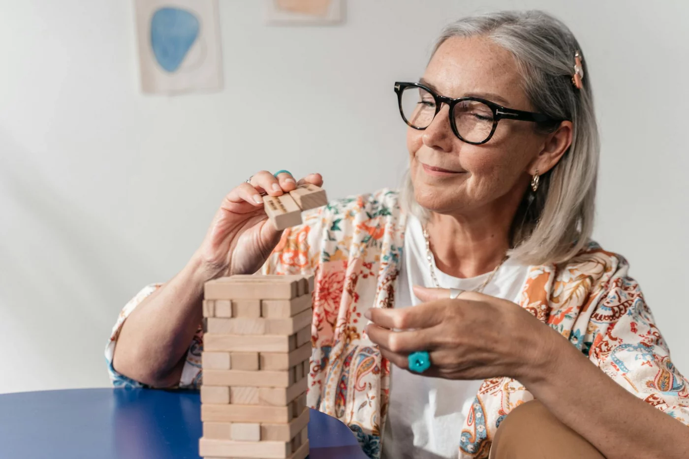 Can You Rewire Your Brain After 40? What Neuroplasticity Shows Woman over 40 playing Jenga indoors, illustrating how long does it take to rewire your brain after 40