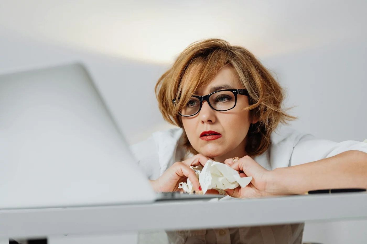Stressed woman at desk shows how to focus in open office environment can be difficult amid constant distractions