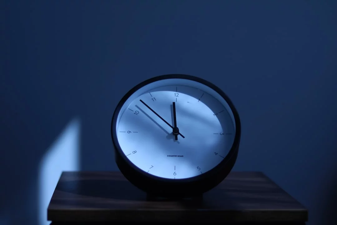 3-2-1 rule sleep hygiene clock on wooden nightstand showing how to improve sleep hygiene before bed