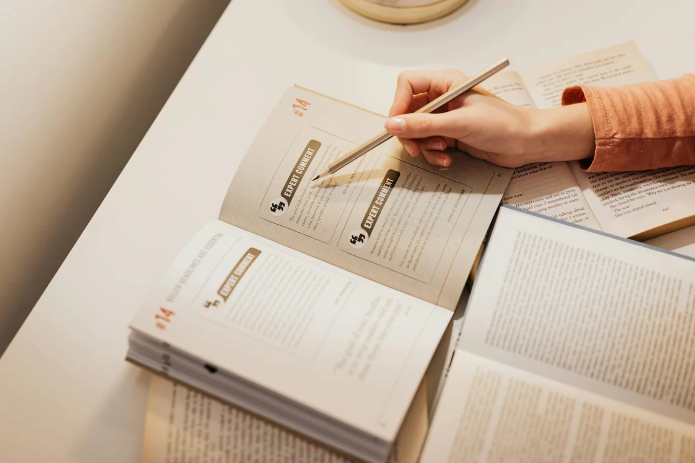 How to Make a Smarter Study Guide for an Exam Student annotating books at a desk, showing how to make a study guide for an exam and review it effectively