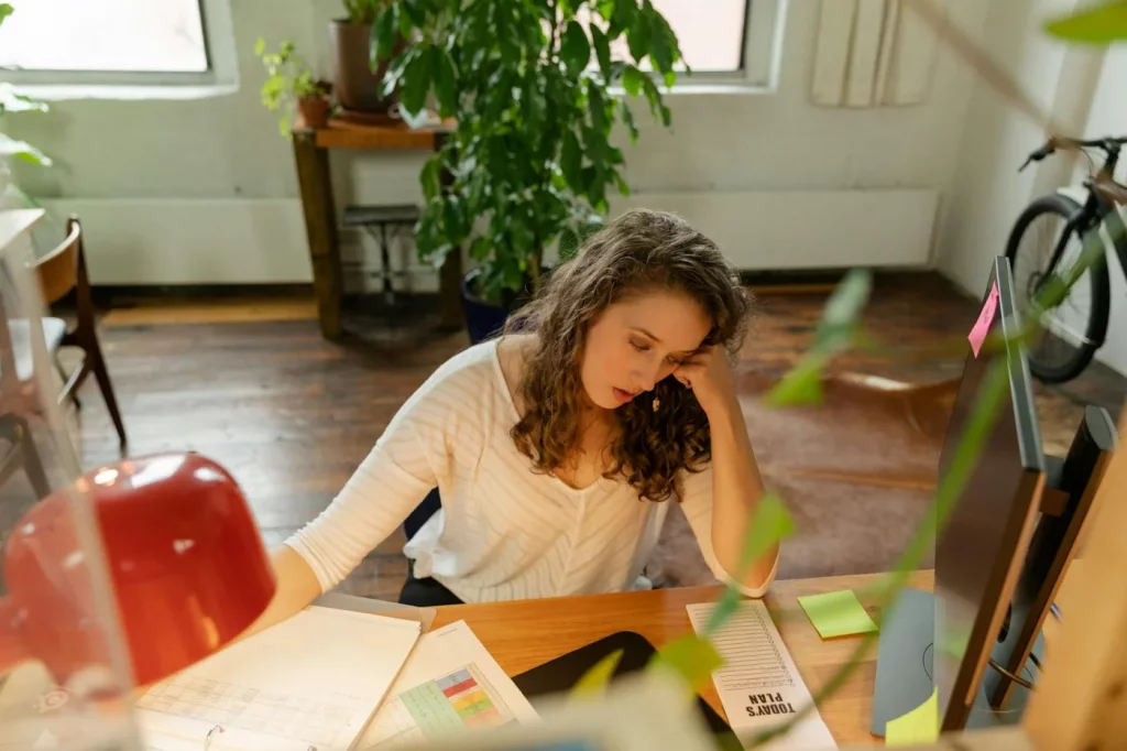 How to Recover from Burnout While Still Working Tired office worker at desk showing how to recover from burnout while still working during a stressful workday
