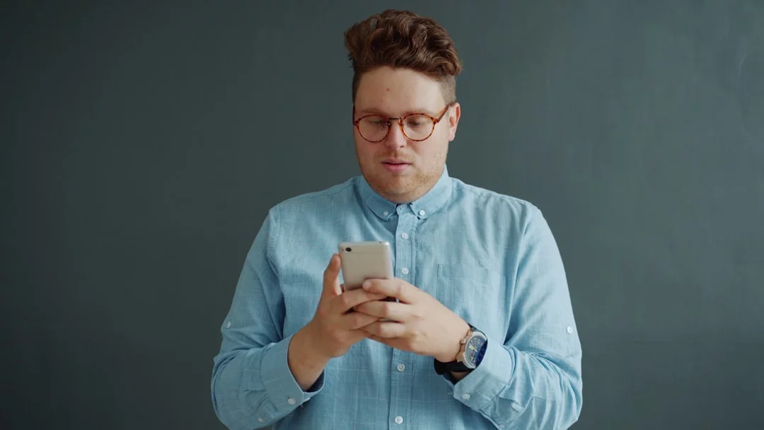 The Distraction Audit steps on how to reduce digital eye strain: man in glasses reviewing phone notifications