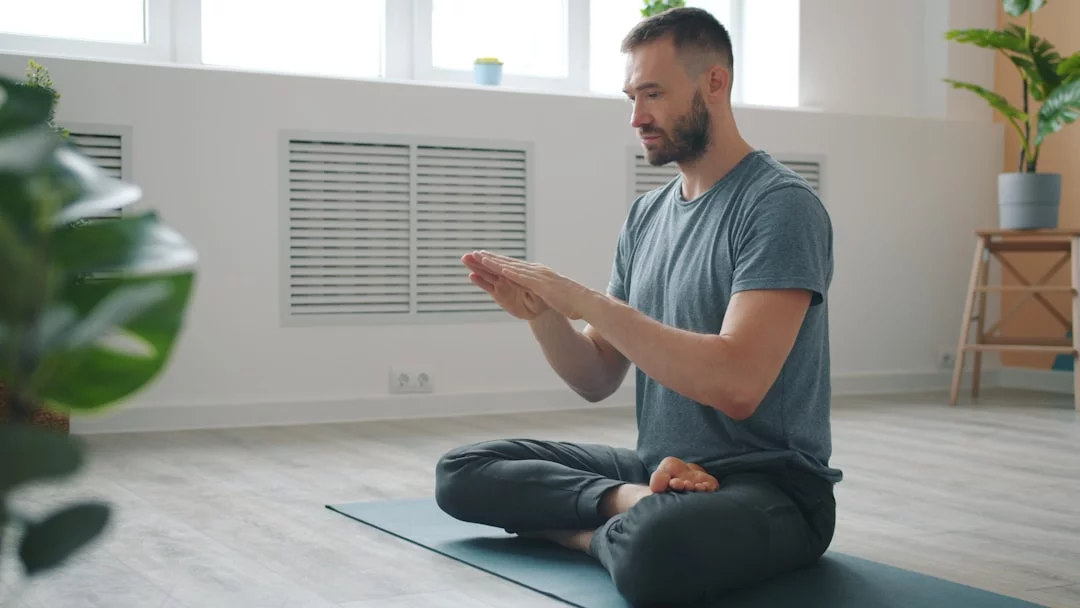 How to Build a Daily Meditation Practice That Actually Sticks Man meditating in a bright minimalist room, showing how to start a daily meditation practice at home