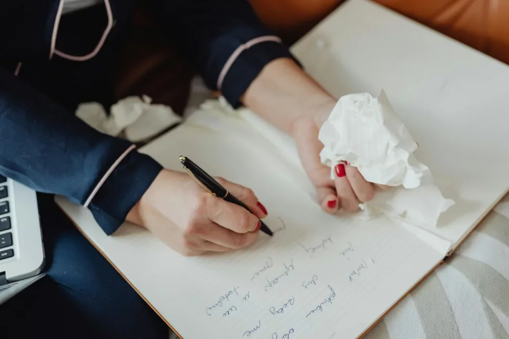 Notebook writing scene illustrating how to stop perfectionism procrastination with messy drafts and ideas