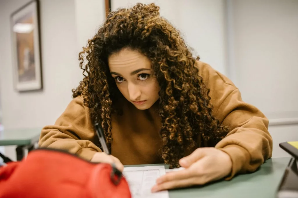 How to Study for AP Exams in the Last 30 Days Without Burning Out Student writing in class while learning how to study for AP exams with a focused 30-day plan