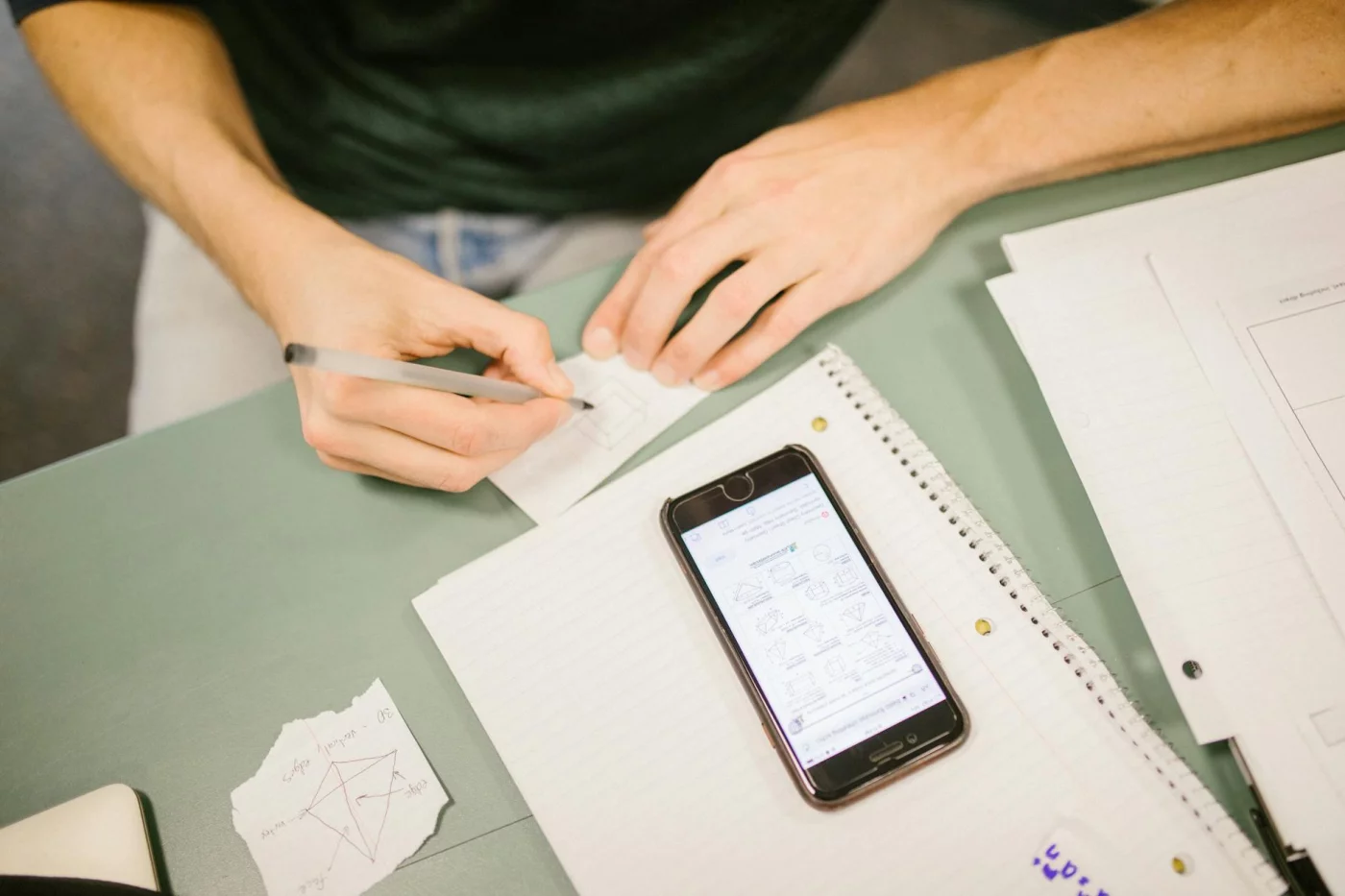 How to Study for AP Exams in the Last 30 Days Without Burning Out Student writing notes beside a phone with diagrams, showing how to study for AP exams with free study aids