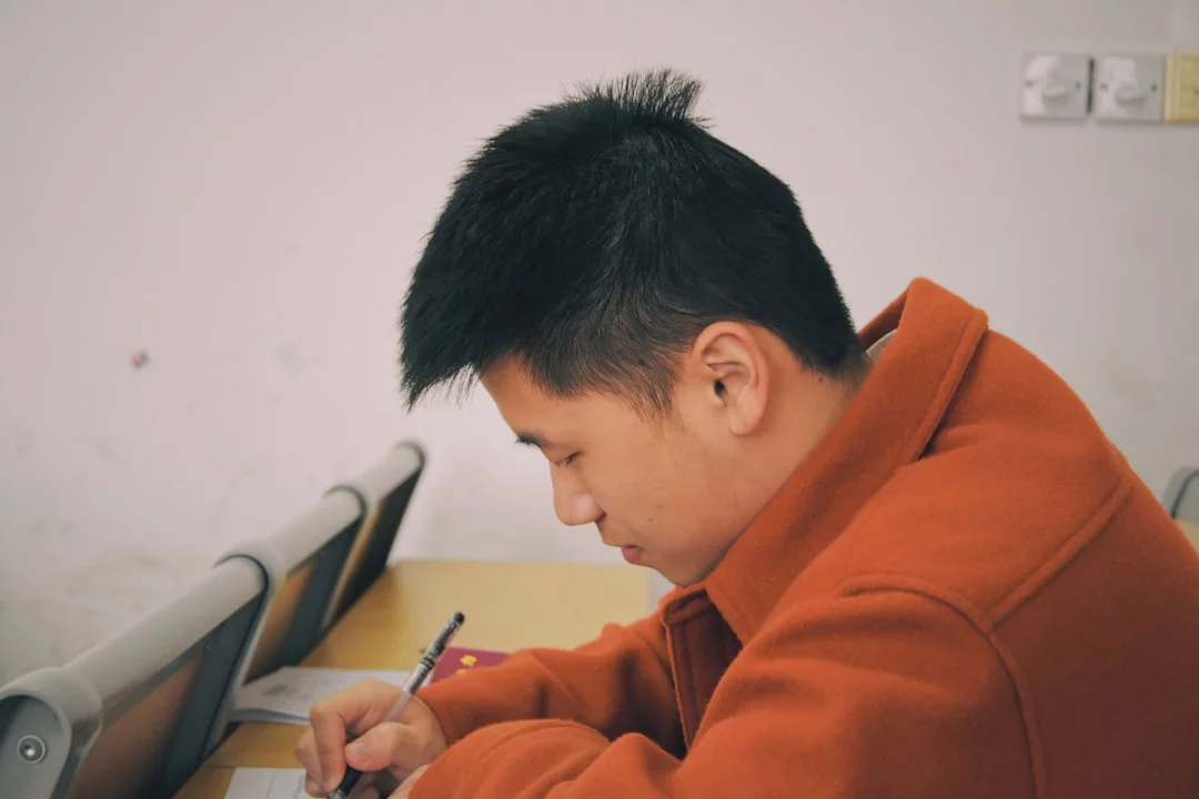Man in orange hoodie uses smartphone timer, showing how to use pomodoro technique for studying with active recall and breaks