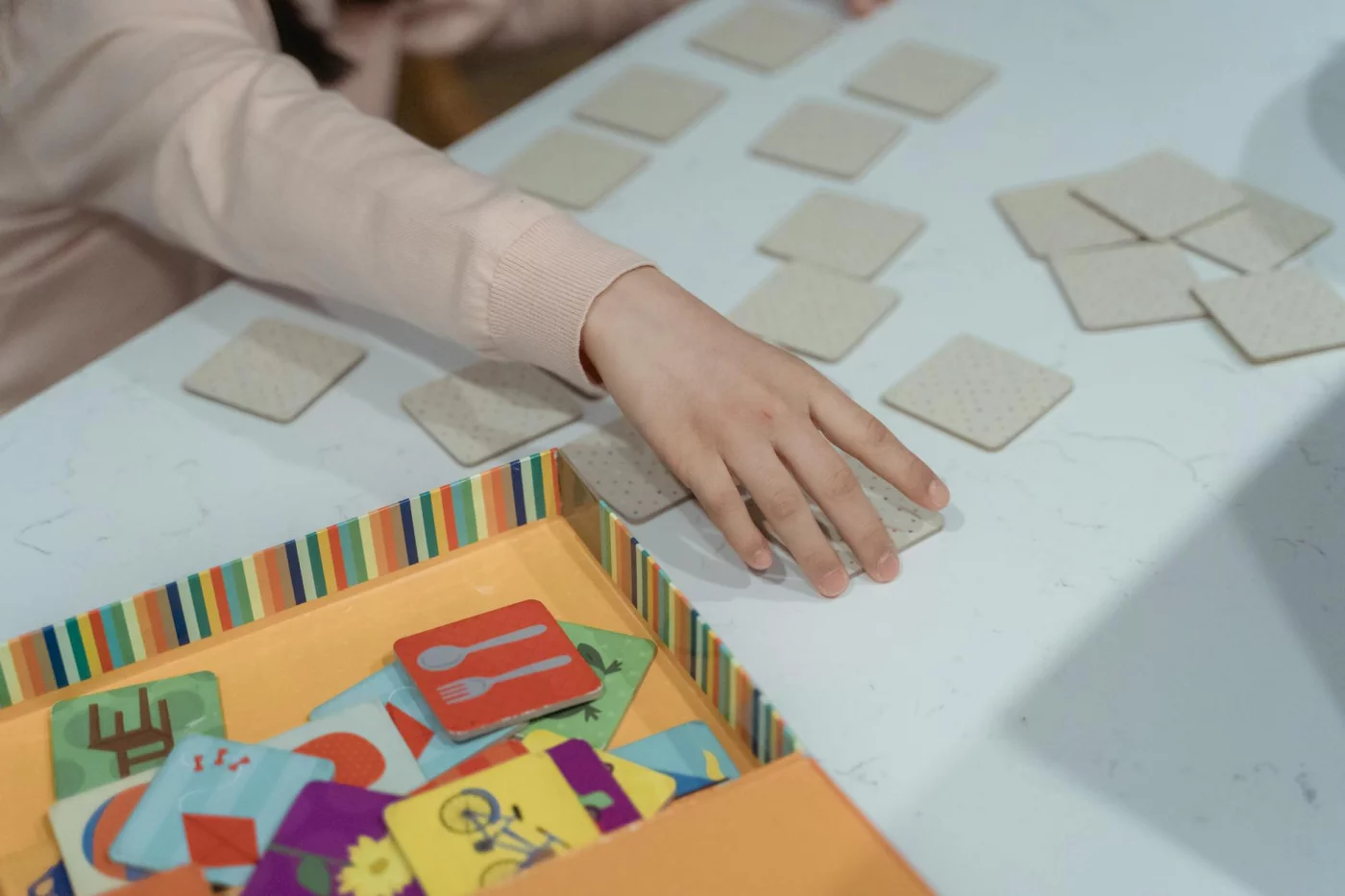 Can Memory Games Improve Recall? What Research Suggests Child playing matching cards during memory games to improve memory, showing focus and concentration
