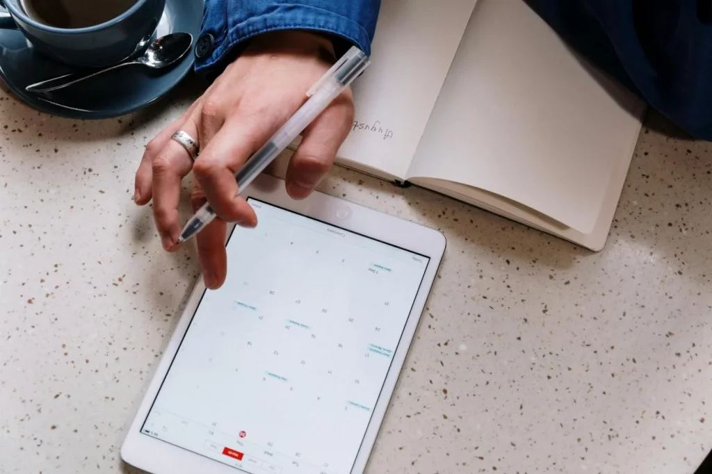 Best Second Brain Apps and Note-Taking Systems Compared Person using a tablet and notebook for planning, comparing second brain apps reddit users recommend