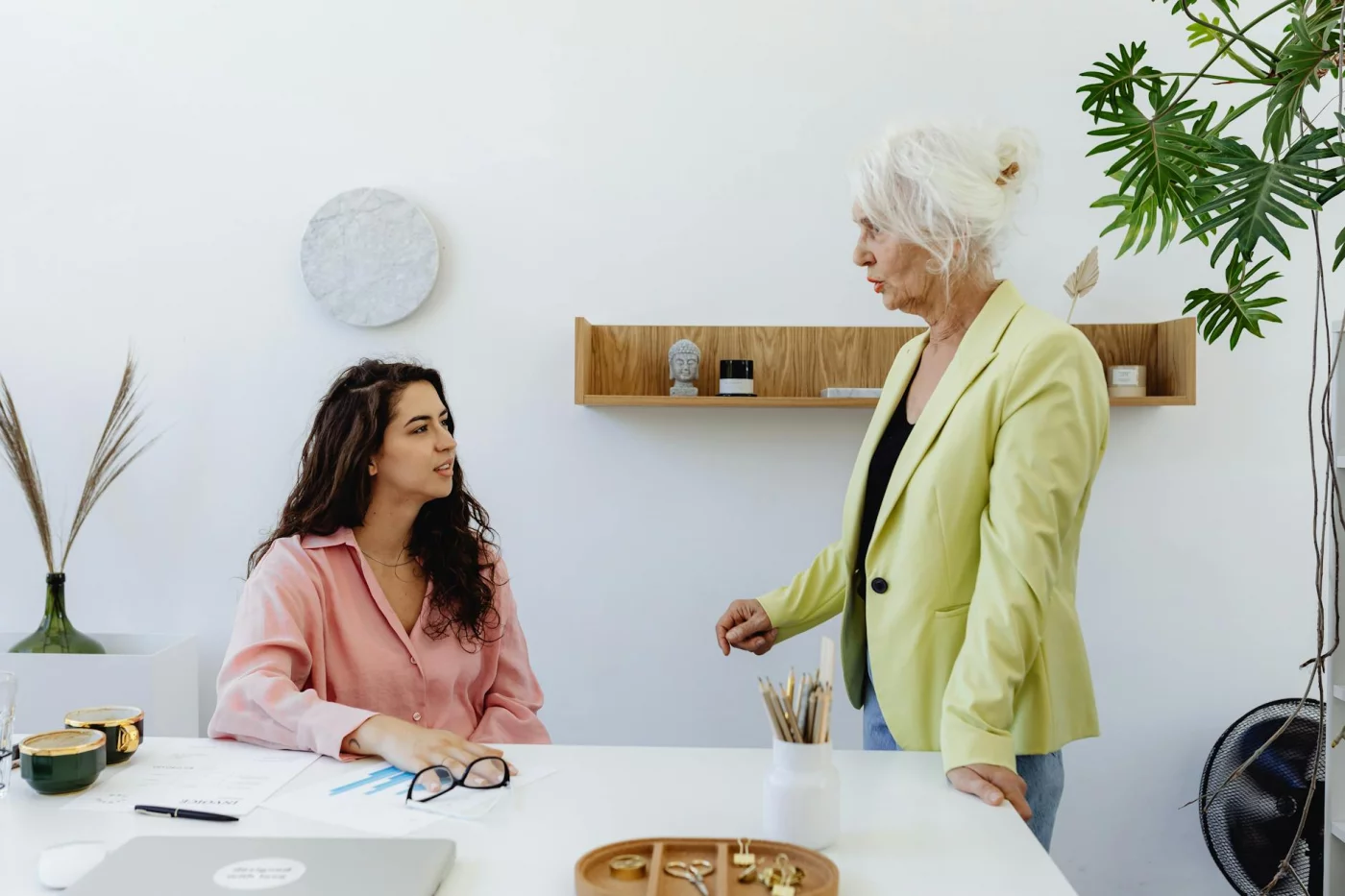 Two women discussing setting personal boundaries at work in a bright office during a professional meeting
