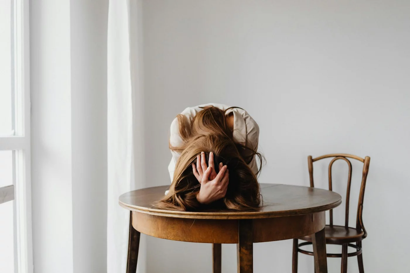 9 Evidence-Based Stress Reduction Techniques for Anxiety That Help Right Now Woman with hands on head indoors seeking fast stress reduction techniques for anxiety during an overwhelming moment