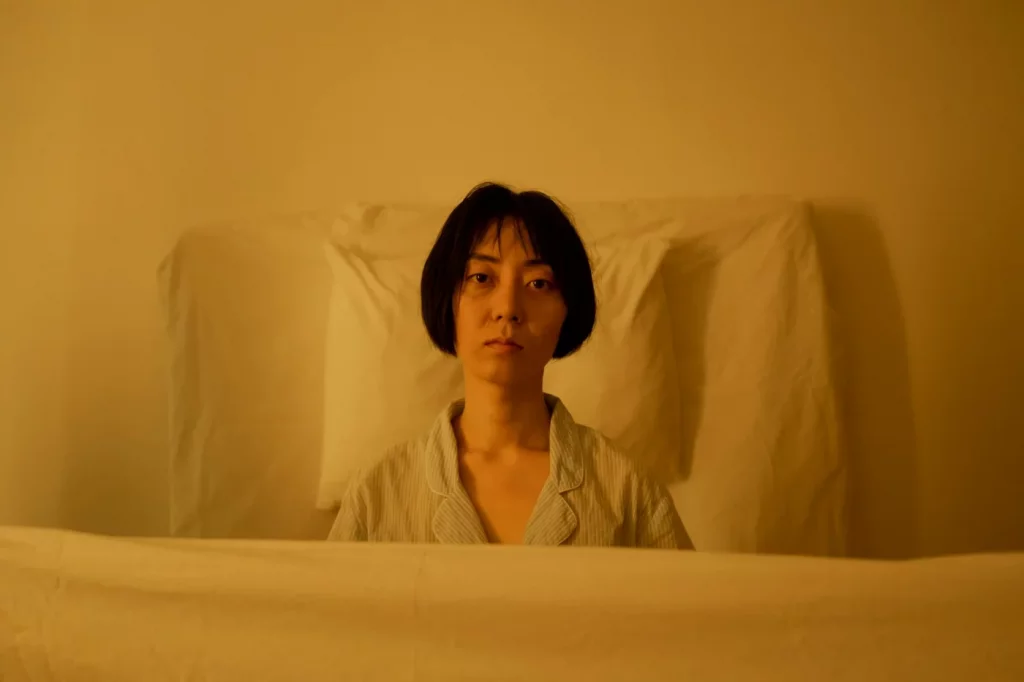 Pensive tired woman in soft lighting illustrating tinnitus and brain fog linked to poor sleep