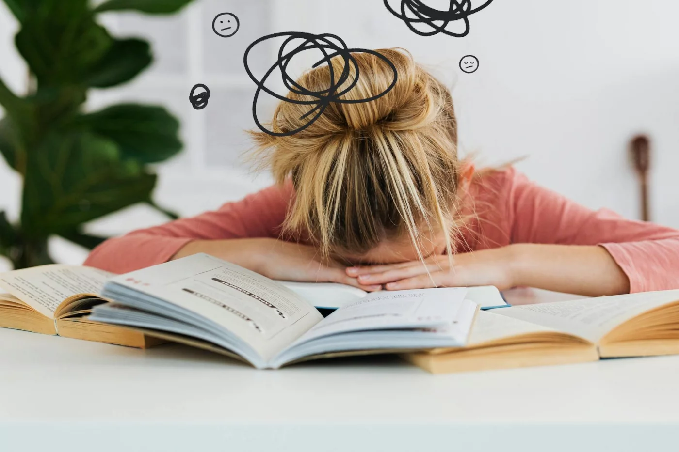 Tinnitus, Brain Fog, and Sleep: How They Connect Woman asleep over books at desk showing how poor sleep can worsen tinnitus and brain fog, stress, and focus