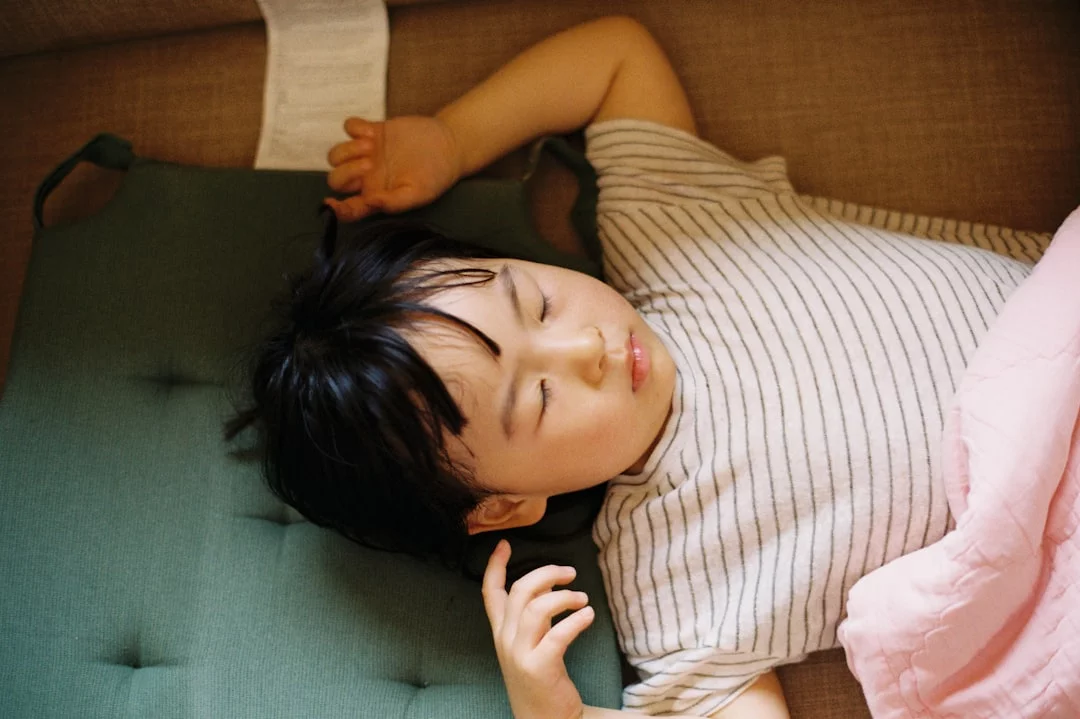 Tinnitus, Brain Fog, and Sleep: How They Connect Woman lying awake on a green bed, illustrating tinnitus and brain fog and a practical sleep plan