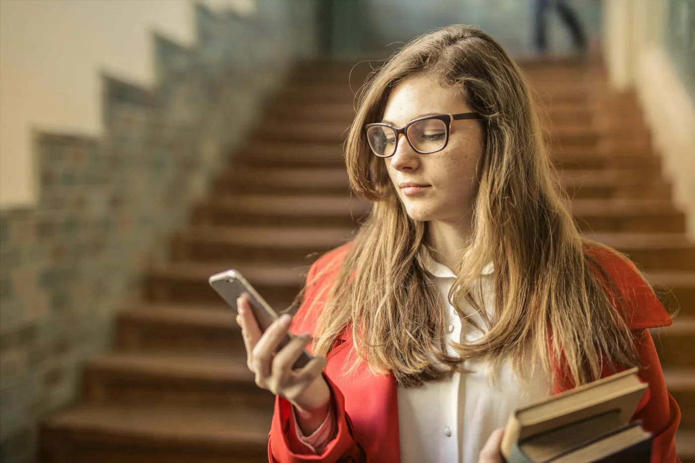 What Is Digital Minimalism for Students? 7 Phone Rules That Actually Work Student checking her smartphone indoors, illustrating what is digital minimalism in everyday campus life