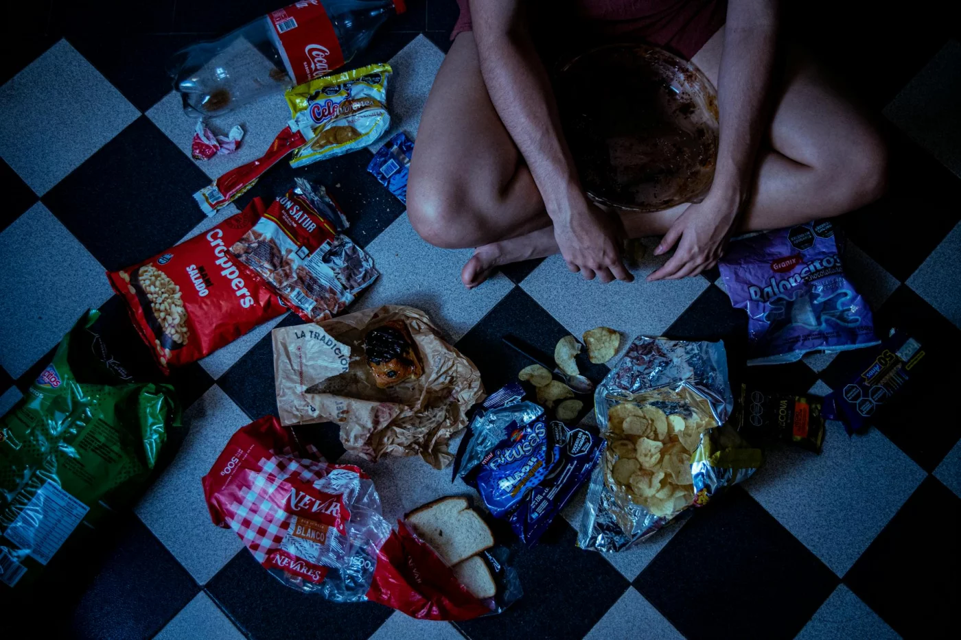 Man surrounded by junk snacks on floor, illustrating what is harming memory: worst foods and the #1 worst habit