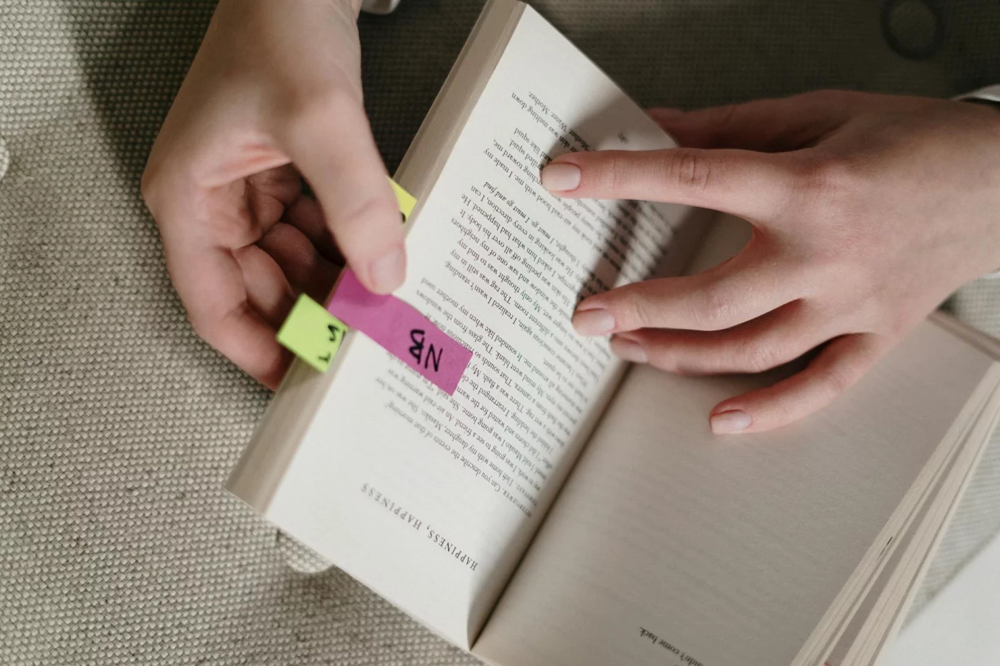 Hands bookmarking a book to explain what is sq3r reading method and its 5 study steps