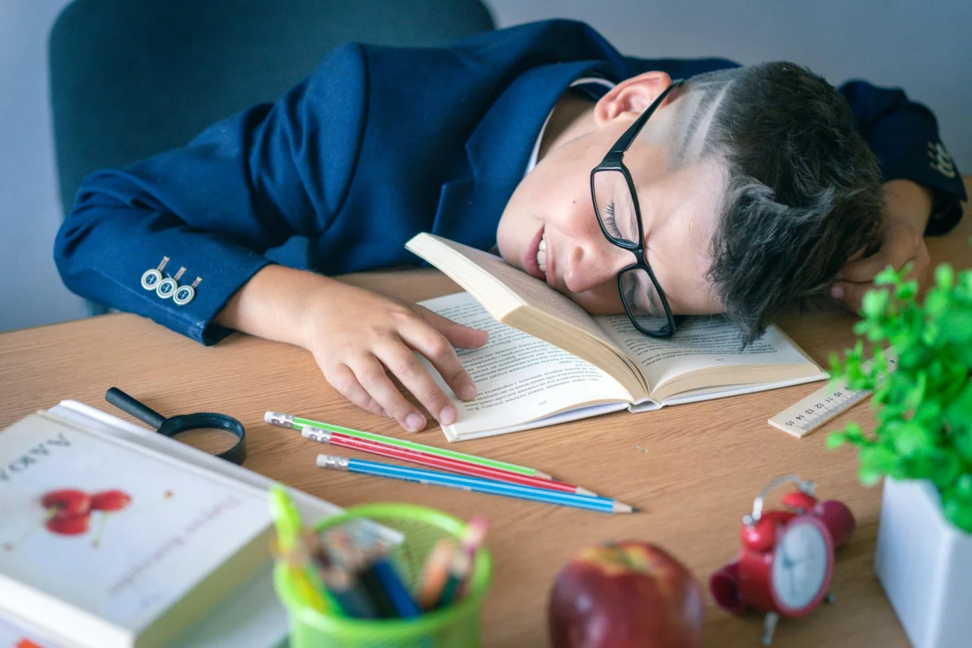 Tired schoolboy resting at his desk, showing why 1 minute mindfulness exercises for students can still help