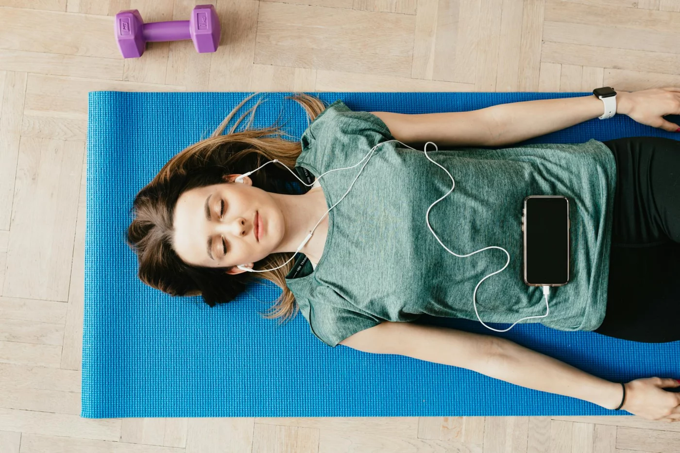 Progressive Muscle Relaxation Script for Fast Stress Relief Woman relaxing on a yoga mat with earphones, illustrating a 5 minute progressive muscle relaxation script