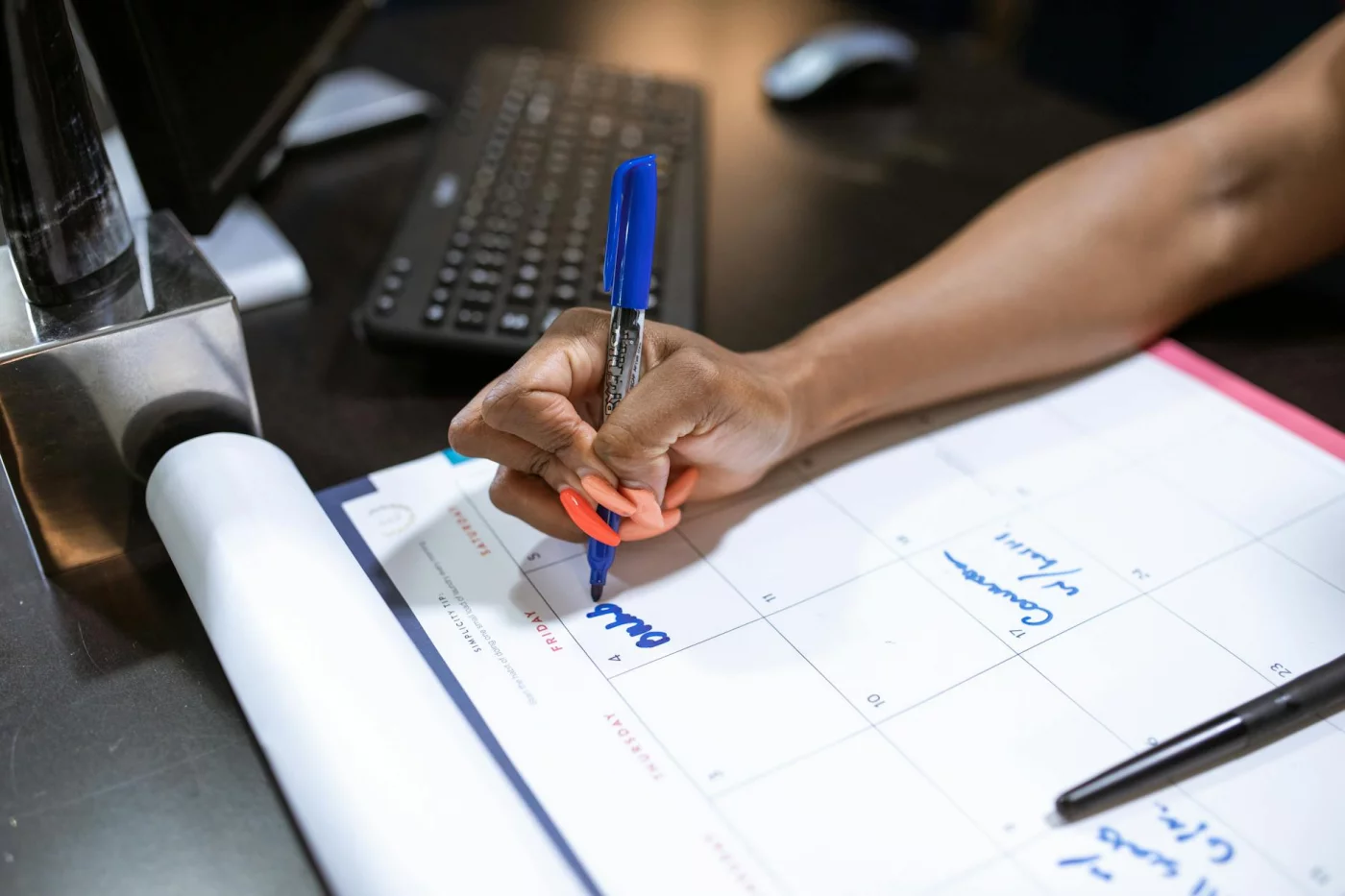 6-Month MCAT Study Schedule: A Realistic 24-Week Plan Planning a 6 month mcat study schedule by writing notes on a calendar with a blue marker