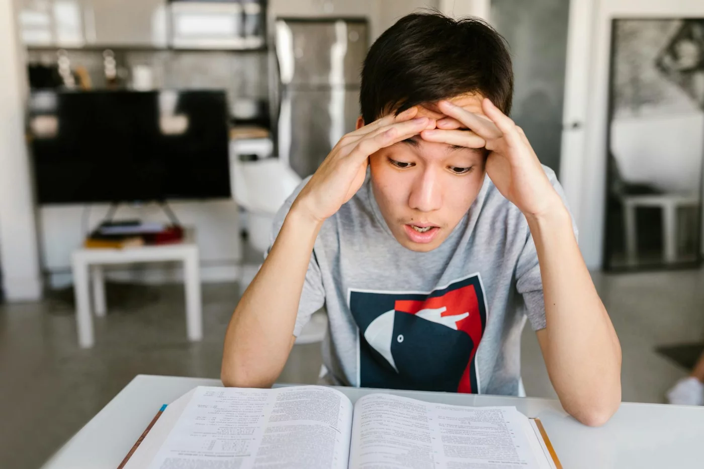 Acronym and Acrostic Mnemonics: Which Works Best for Recall? Student stressed over books at home, showing where acrostic mnemonic examples may fail to improve recall