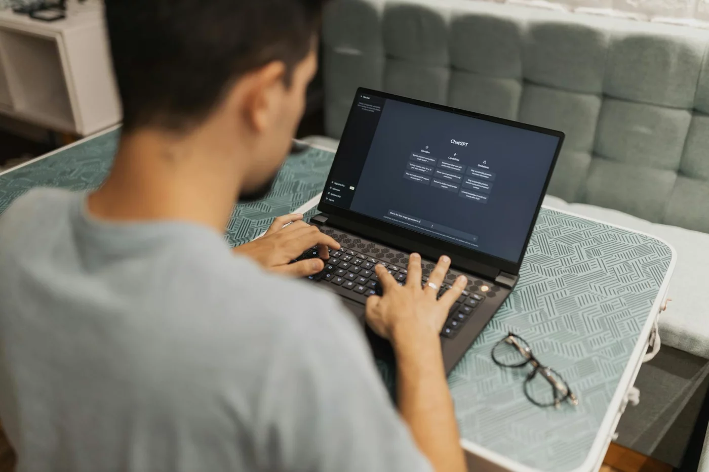 What AI Slop in the Workplace Really Means for Productivity Worker using ChatGPT on a laptop while researching ai slop in the workplace FAQs