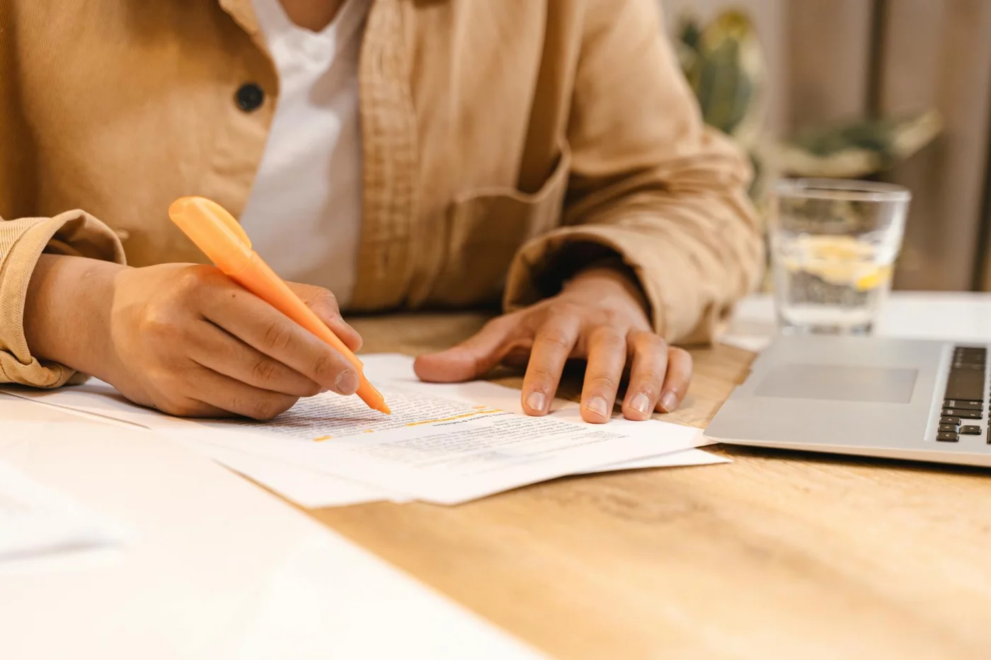 Anki vs SuperMemo vs RemNote: Which SRS App Fits You Best? Student highlighting notes at a desk beside a laptop, illustrating anki vs remnote reddit and real SRS study habits