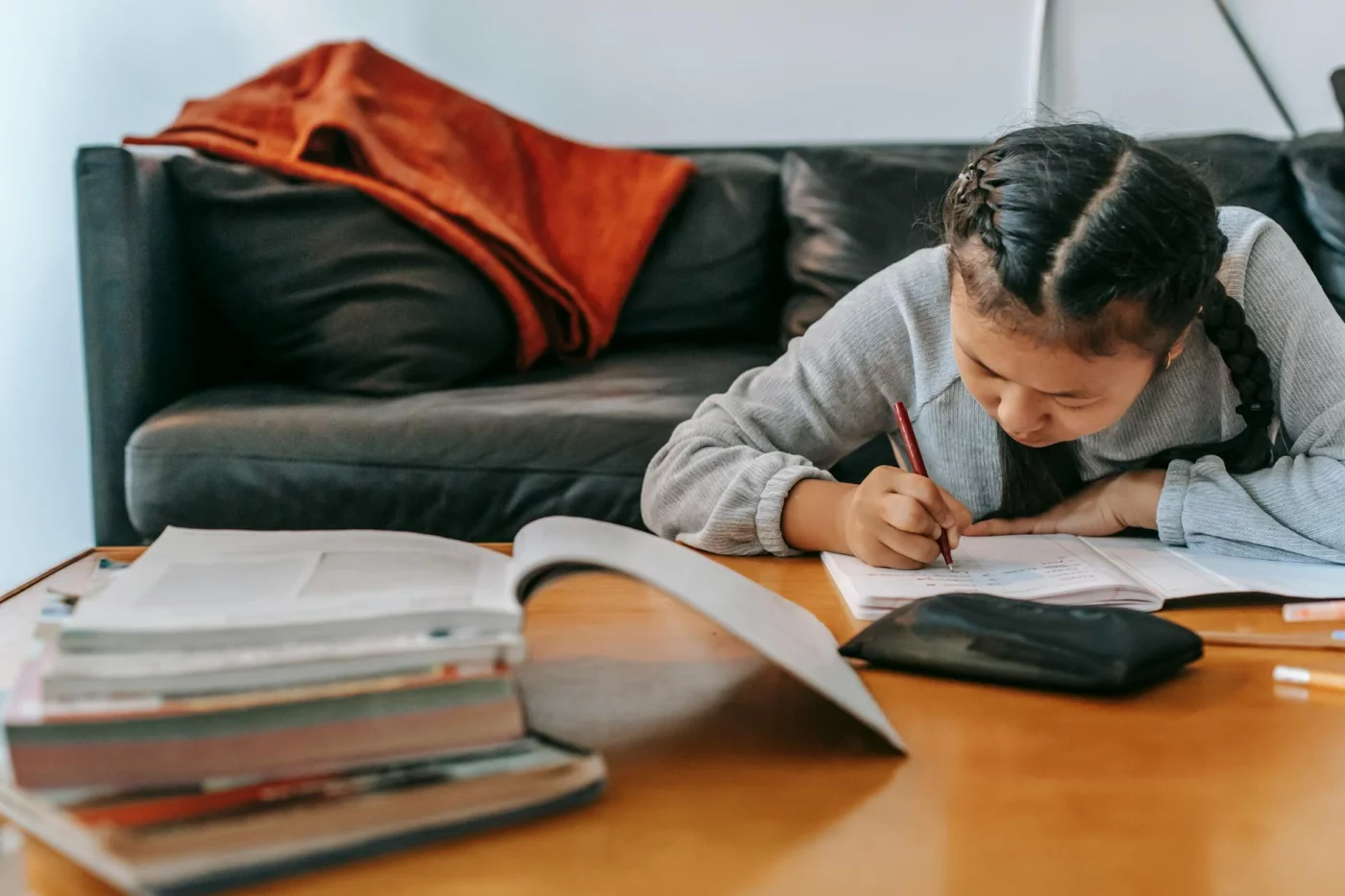 Schoolchild doing homework at home, showing attention and working memory while writing in a workbook