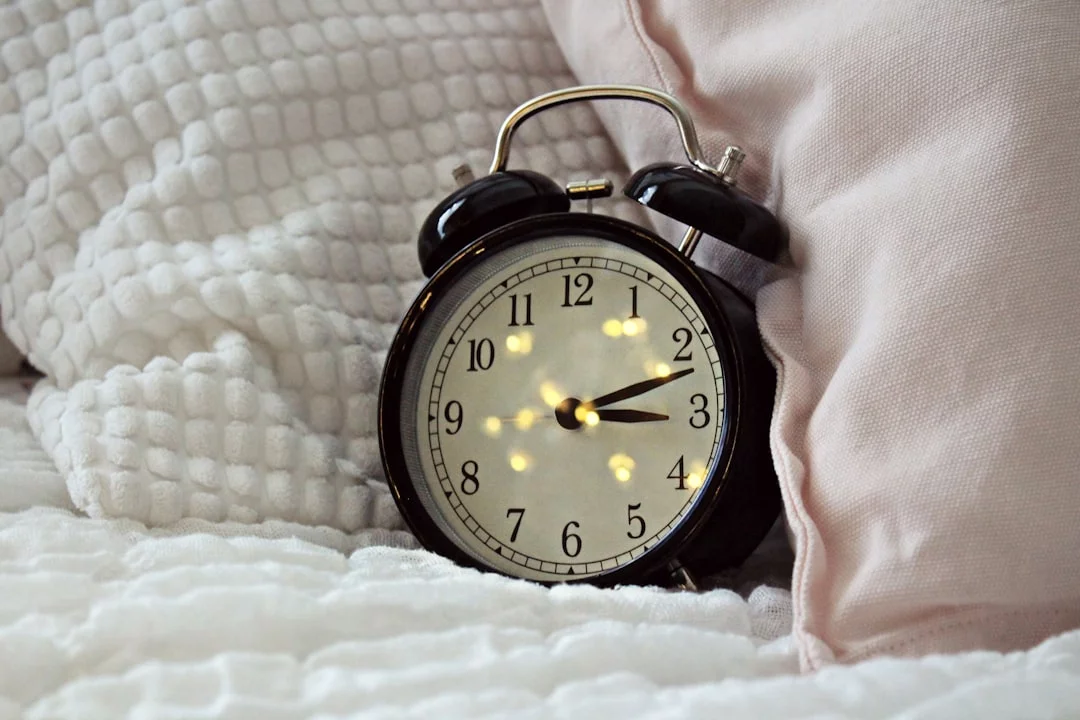 How to Build a Bedtime Routine for Adults That Helps You Fall Asleep Faster Round black alarm clock showing 3:12, a reminder to set one anchor time in a bedtime routine for adults