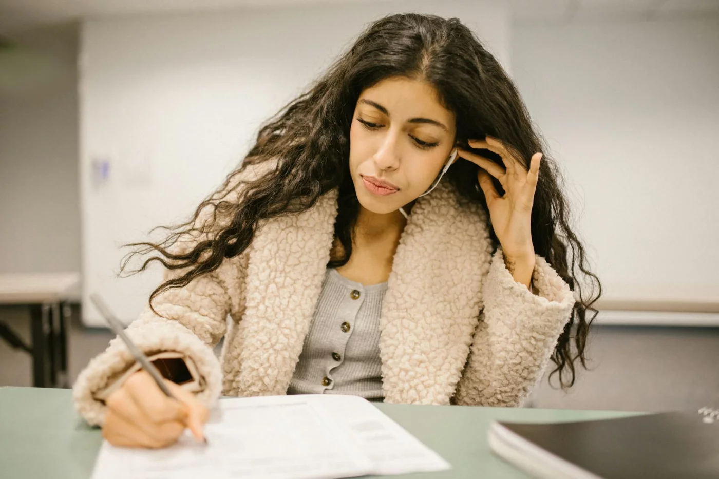 Duolingo vs Babbel vs Pimsleur: Which App Is Best in 2026? Student using earphones while studying, comparing the best language learning apps free for focused practice