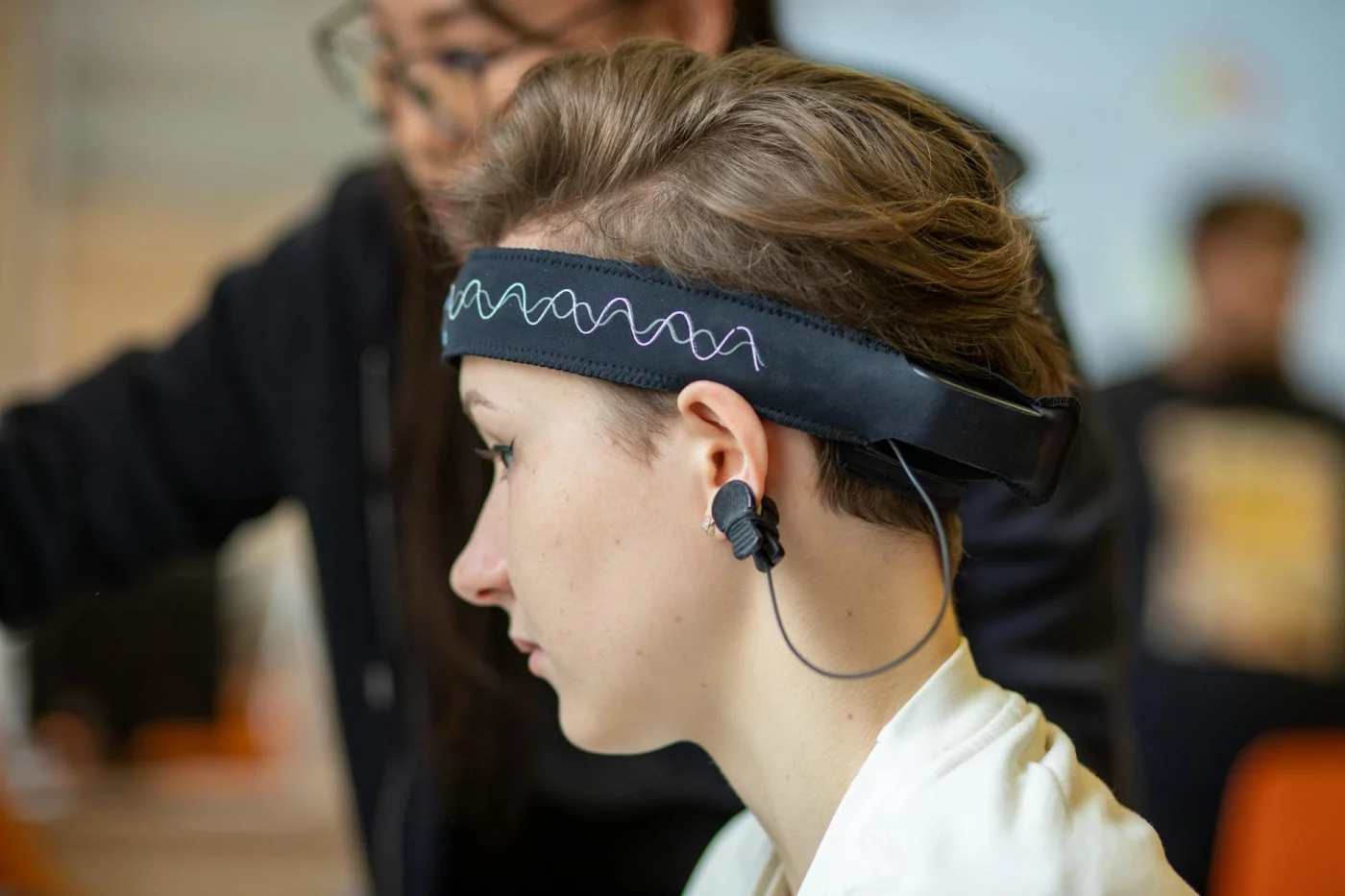 Binaural Beats vs Lo-fi vs Silence for Focus Young woman wearing an EEG headband indoors as research explores binaural beats for studying