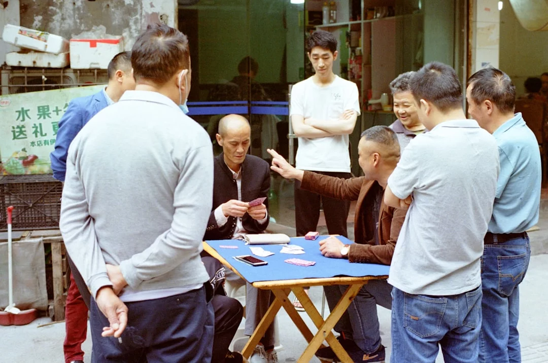 Do Brain Exercises to Improve Concentration Really Help Daily Focus? Men gathered around a table playing cards while discussing brain exercises to improve concentration
