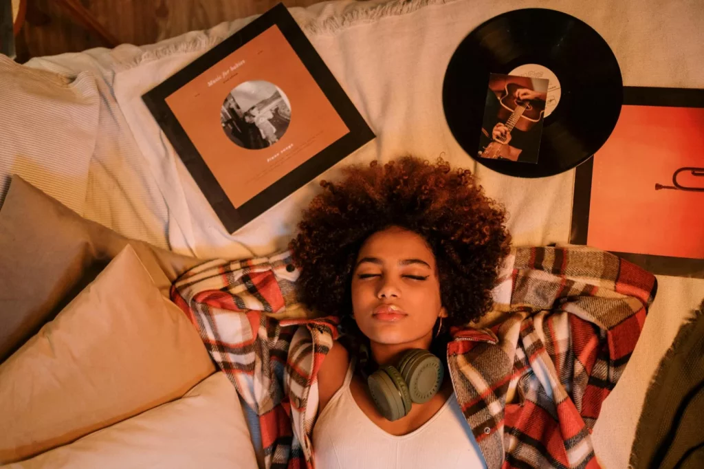 Can You Learn While You Sleep? 7 Science-Backed Answers Woman relaxing indoors with vinyl records, exploring can you learn while you sleep listening in a calm setting